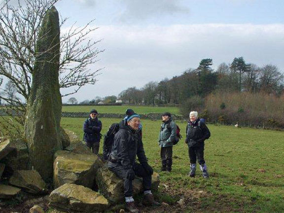 3.Gaerwen – Bryn Celli Ddu
15/03/15. A minor detour to see the standing stone at Carreg Boeth farm. Ian takes a breather. Photo: Dafydd Williams
Keywords: Mar15 Sunday Noel Davey