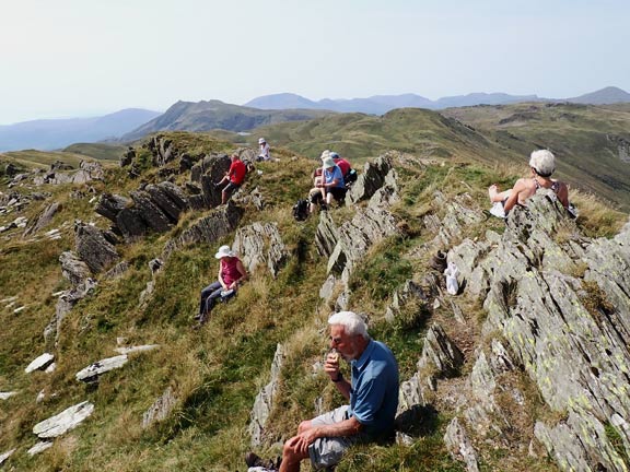 3.Moel Druman - Yr Arddu
14/08/22. Final a late lunch and a rest. On top of Allt Fawr 2201ft. No shade from the sun. Nor for some, shelter from the flying ants. But then if you sit on their nest!
Keywords: Aug22 Sunday Hugh Evans