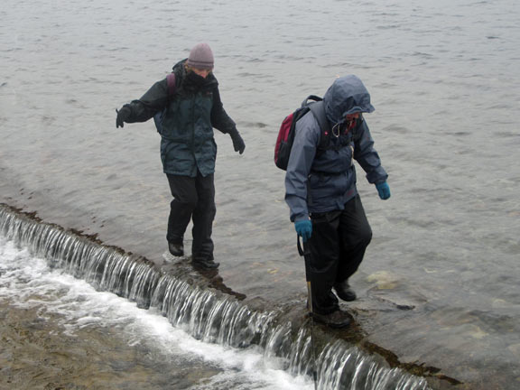 The spillway at Llyn Llygad Rheidol as members make their way across.