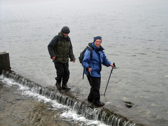 The spillway at Llyn Llygad Rheidol as members make their way across.